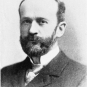 Black and white photograph of man in a suit with full beard