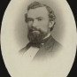 Black and white photograph of a man in a suit with full beard