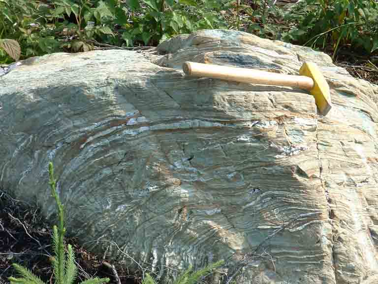Photographie couleur d’une roche grise et d’un marteau comme valeur d'échelle