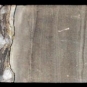 Image couleur de roche brune longue et étroite, à sections tachetées de roc blanc et gris