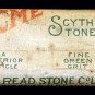 Photographie couleur d’une étiquette « ACME Scythe Stone » sur une roche grise