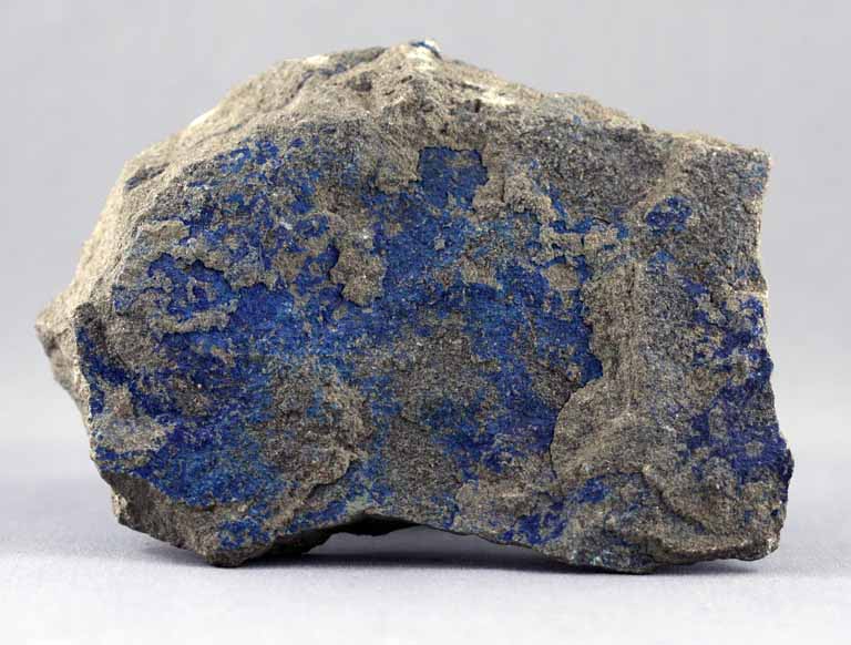 Photographie couleur d’une roche grise avec des cristaux bleus