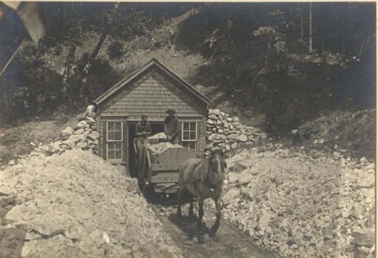 Black and white photograph of horse, wagon and two men