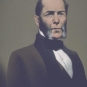 Colour image of man with side whiskers in a suit