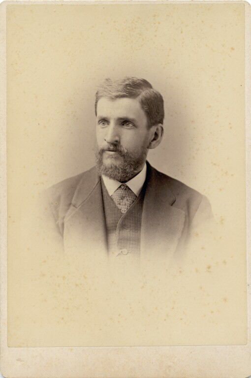 Black and white photograph of man in a suit with full beard