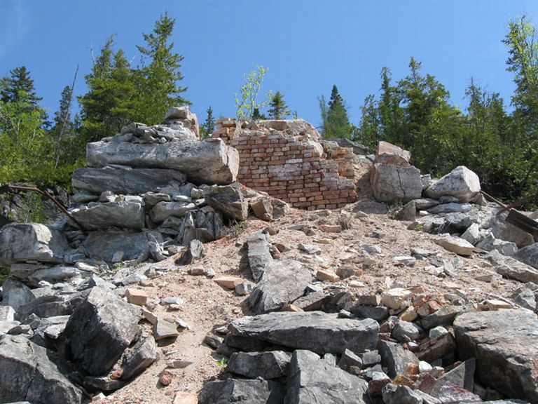Colour photograph of hillside with scattered rocks and bricks