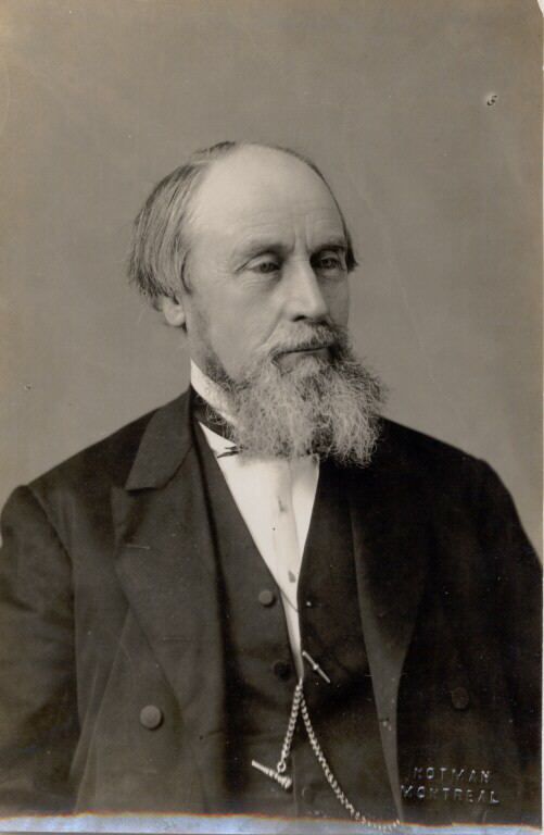 Photographie noir et blanc d'un homme portant un complet et une longue barbe