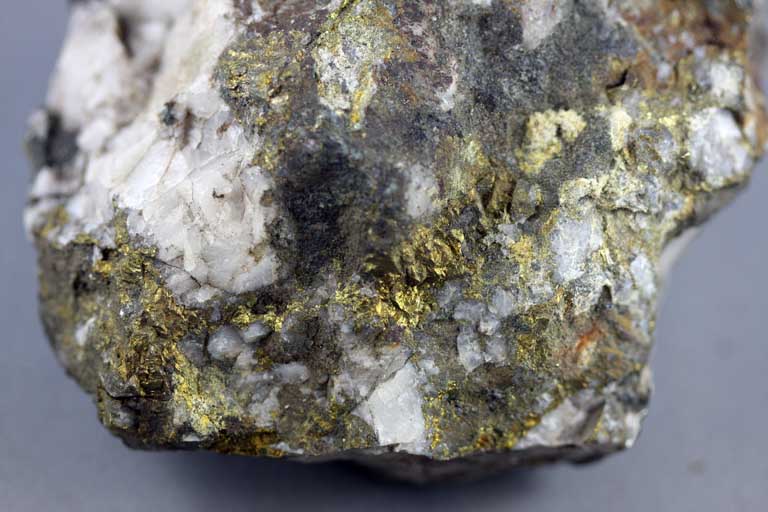 Colour image of brown rock mottled with white and yellow spots