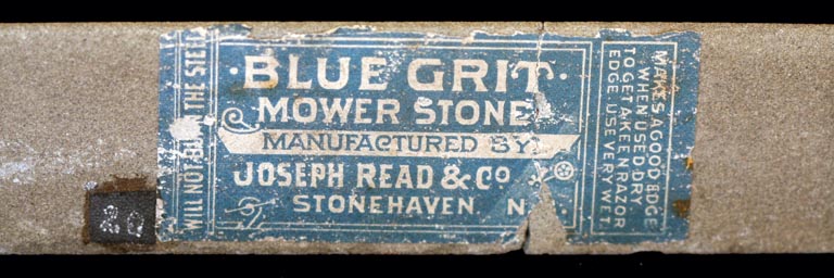 Colour photograph of a label ‘Blue Grit Mower Stone’ on a gray rock