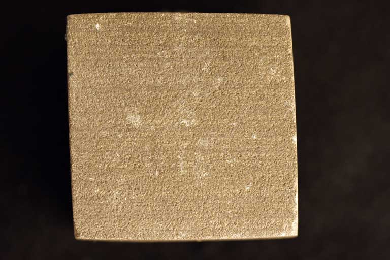 Colour photograph of a brown sandstone cube