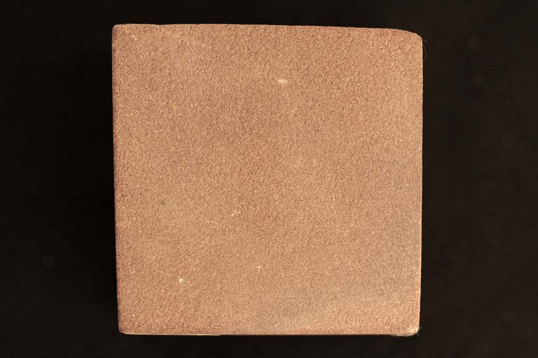 Colour photograph of a red sandstone cube
