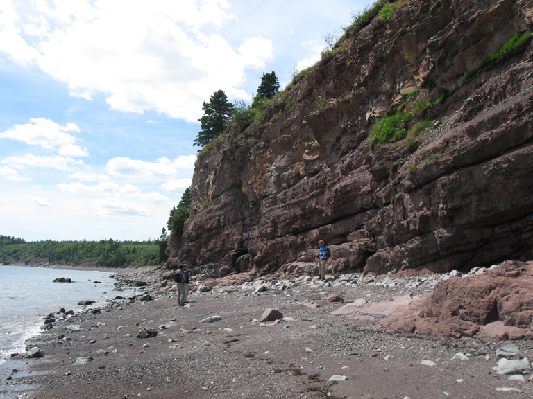 Colour photograph of a man standing in front of pink rocks