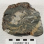 Colour image of gray rock with gold, white and orange streaks