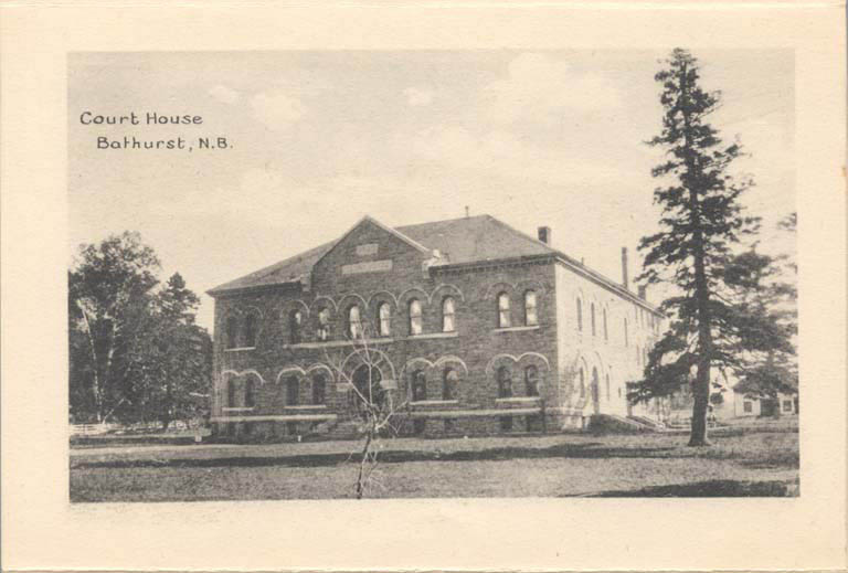 Black and white postcard of large, square stone building with curved window casings