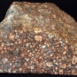 Colour image of brown rock mottled with black and yellow spots