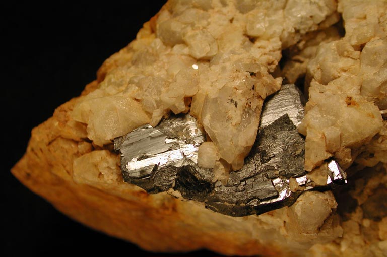 Colour image of orange rock with gay metallic rock showing through cracks