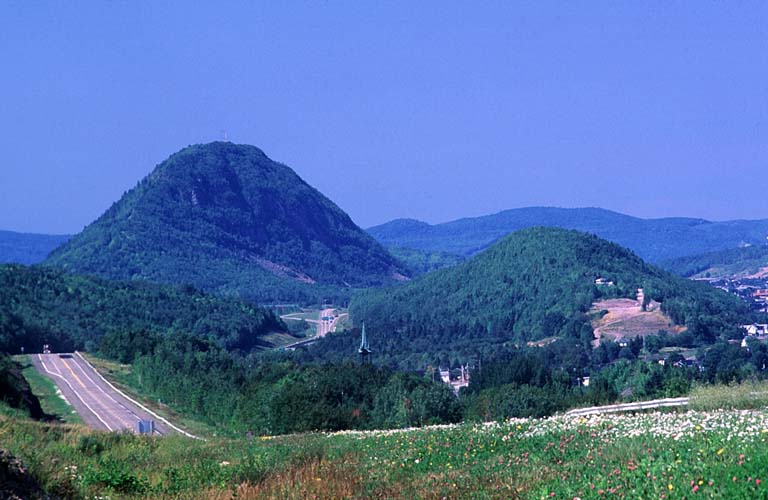 Colour photograph of highway and two large mountains in background