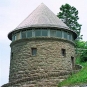 Colour photograph of round stone tower with pointed roof