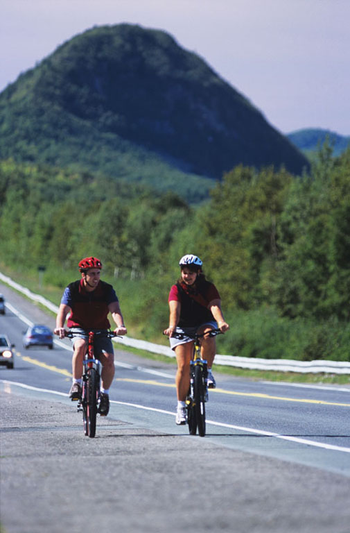 Photographie couleur d’une route avec deux grosses montagnes en arrière-plan