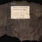 Colour image of brown rock with vertical striping and paper label