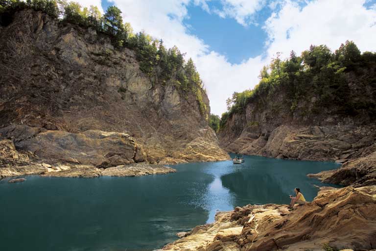 Colour image of rocky cliffs on both sides of calm river
