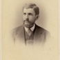 Black and white photograph of man in a suit with full beard