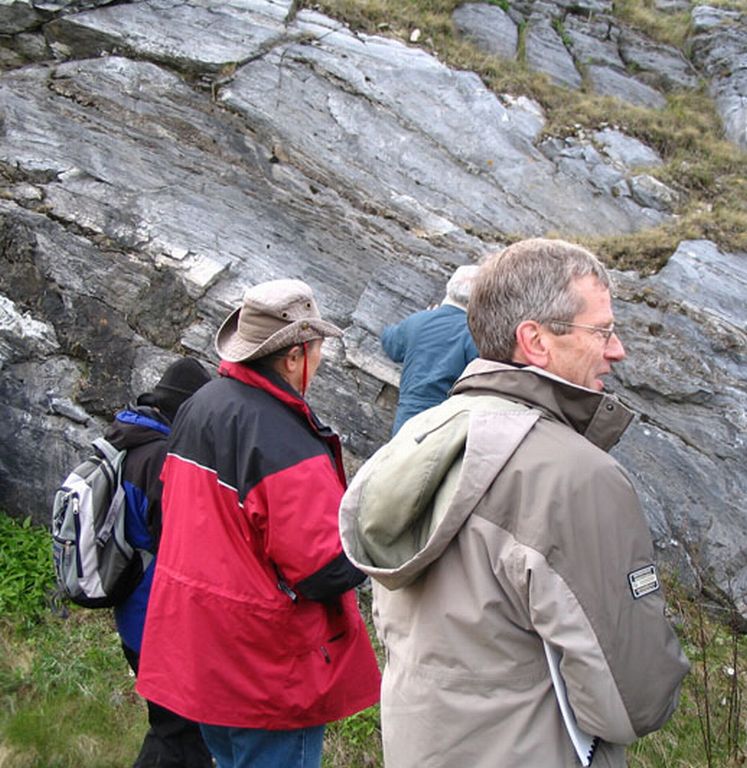 Colour photograph of woman and man near rock face