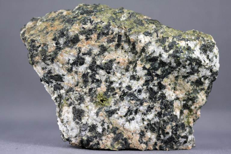 Colour image of gray rock with black and green spots