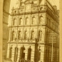 Black and white photograph of four storey stone building with mansard roof