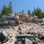 Colour photograph of hillside with scattered rocks and bricks