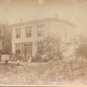 Black and white photograph of two storey house and front garden