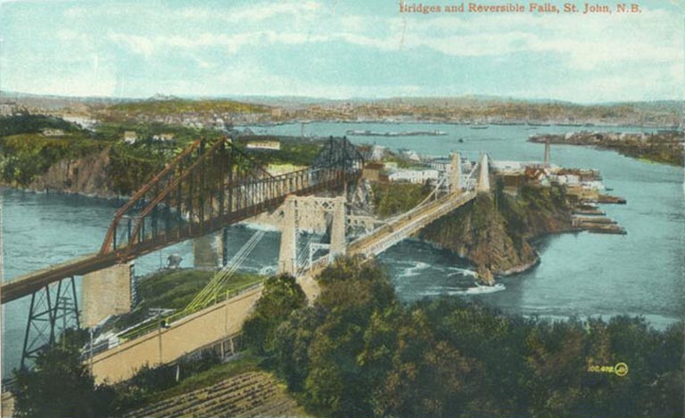 Image couleur montrant pont ferroviaire en acier, pont suspendu, cours d’eau et port