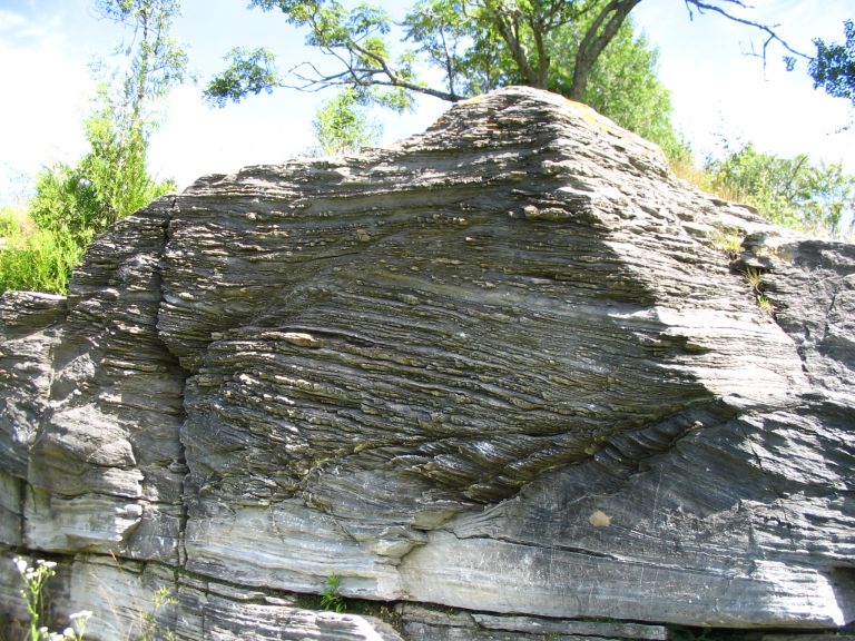 Photographie couleur d’une roche grise avec rayures horizontales