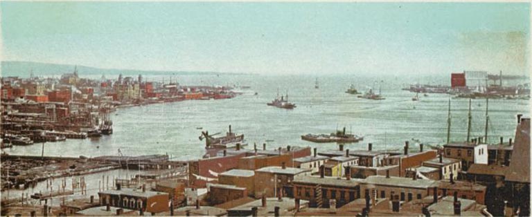 Image couleur montrant le port et des bateaux et, en arrière-plan, la ville