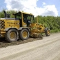 Grader rebuilding a gravel road