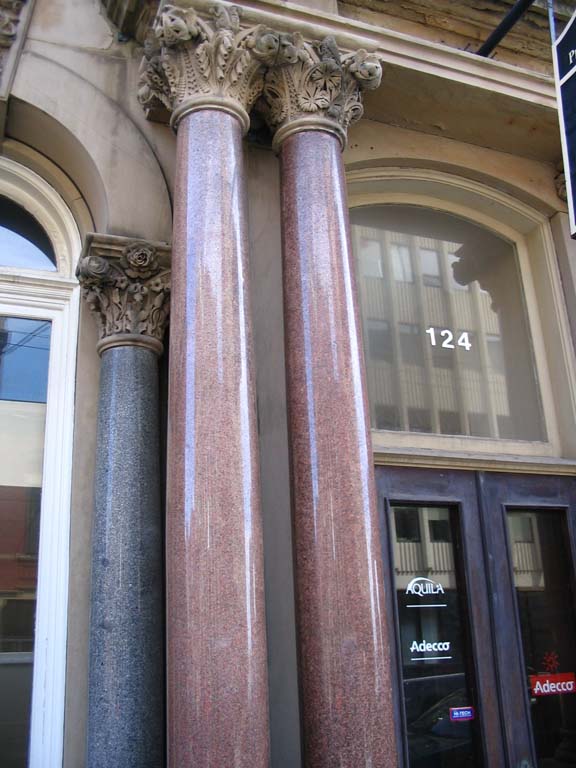 Colour photograph of red columns at entrance to stone building