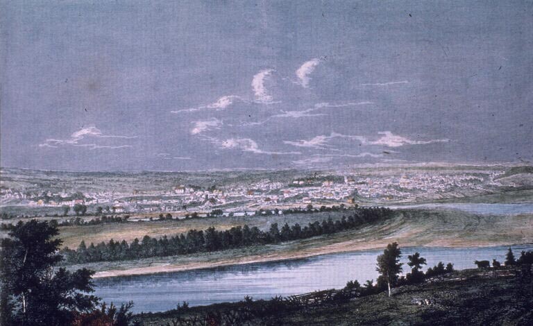 Estampe couleur illustrant un ciel très bleu, un cours d’eau et une localité au loin