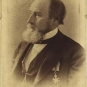 Black and white photograph of a man with a beard and wearing a suit