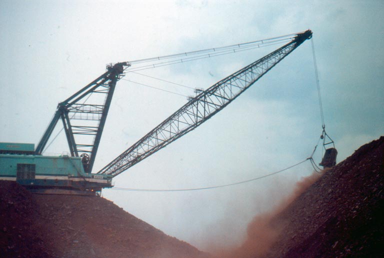 Colour photograph of a crane shovelling rock