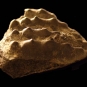 Colour photograph a brown rock with four rows of small bumps on top of it